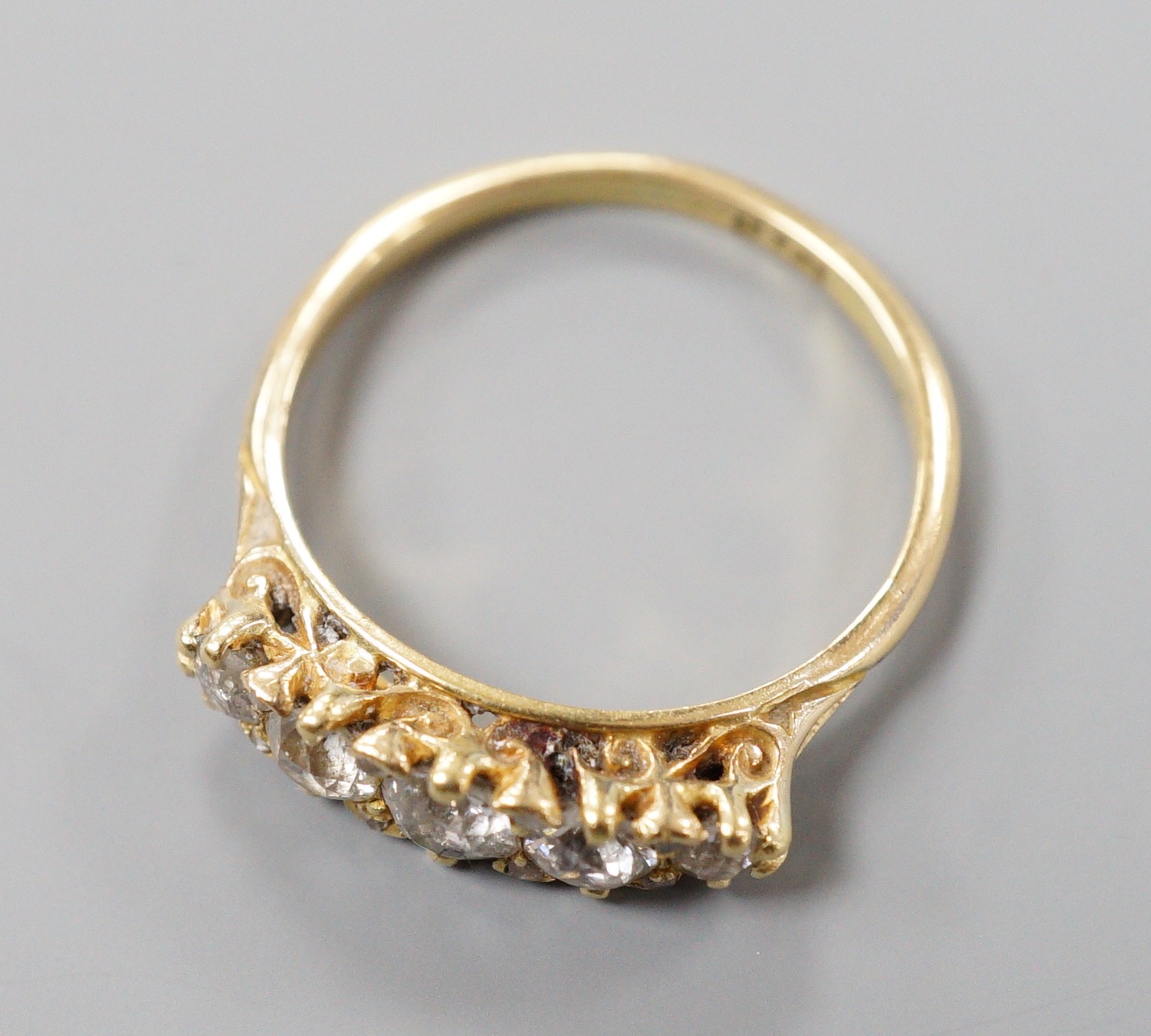 An early 20th century 18ct and graduated five stone diamond set half hoop ring, size P/Q, gross weight 3.2 grams.